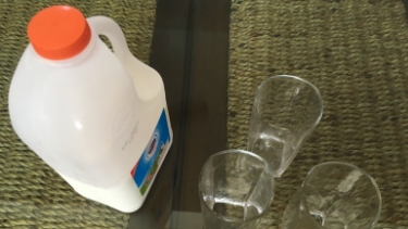 Milchflasche mit drei Gläsern